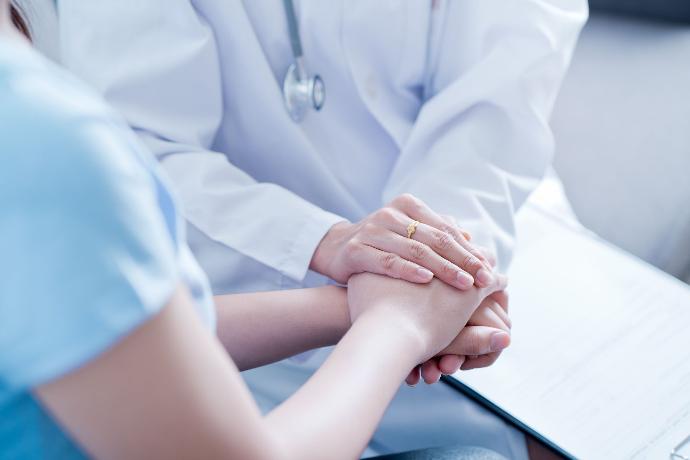 Verpleegkundige houdt de hand vast van een jong persoon