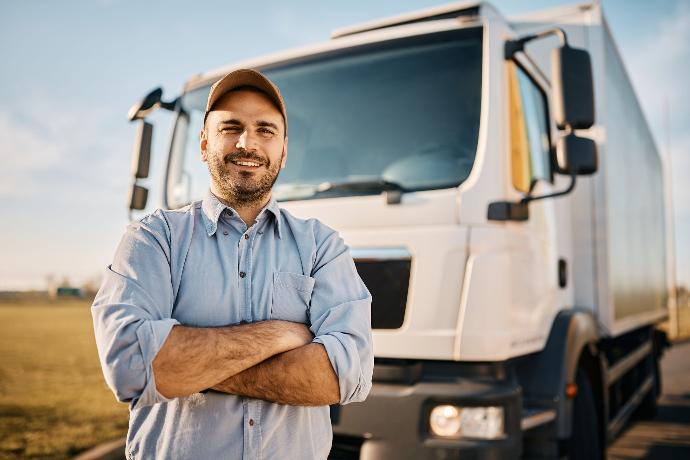 Vrachtwagenchauffeur poserend voor zijn vrachtwagen.