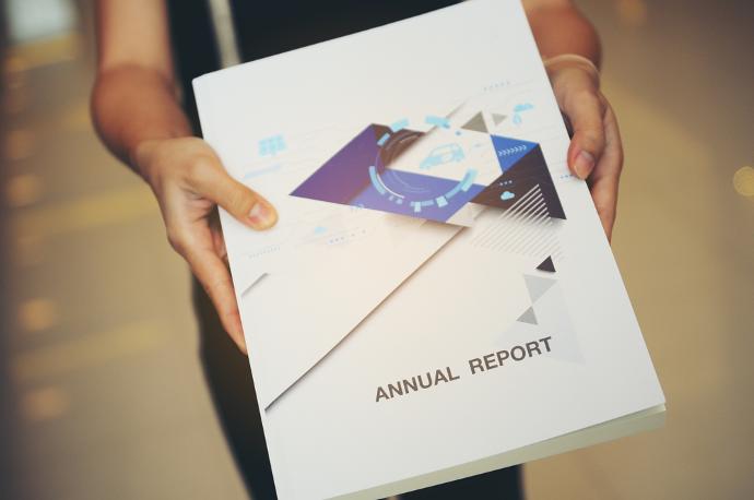 Vrouw die een map vasthoudt met 'Annual Report' erop