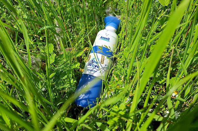 Gepersonaliseerde waterfles verborgen tussen het gras